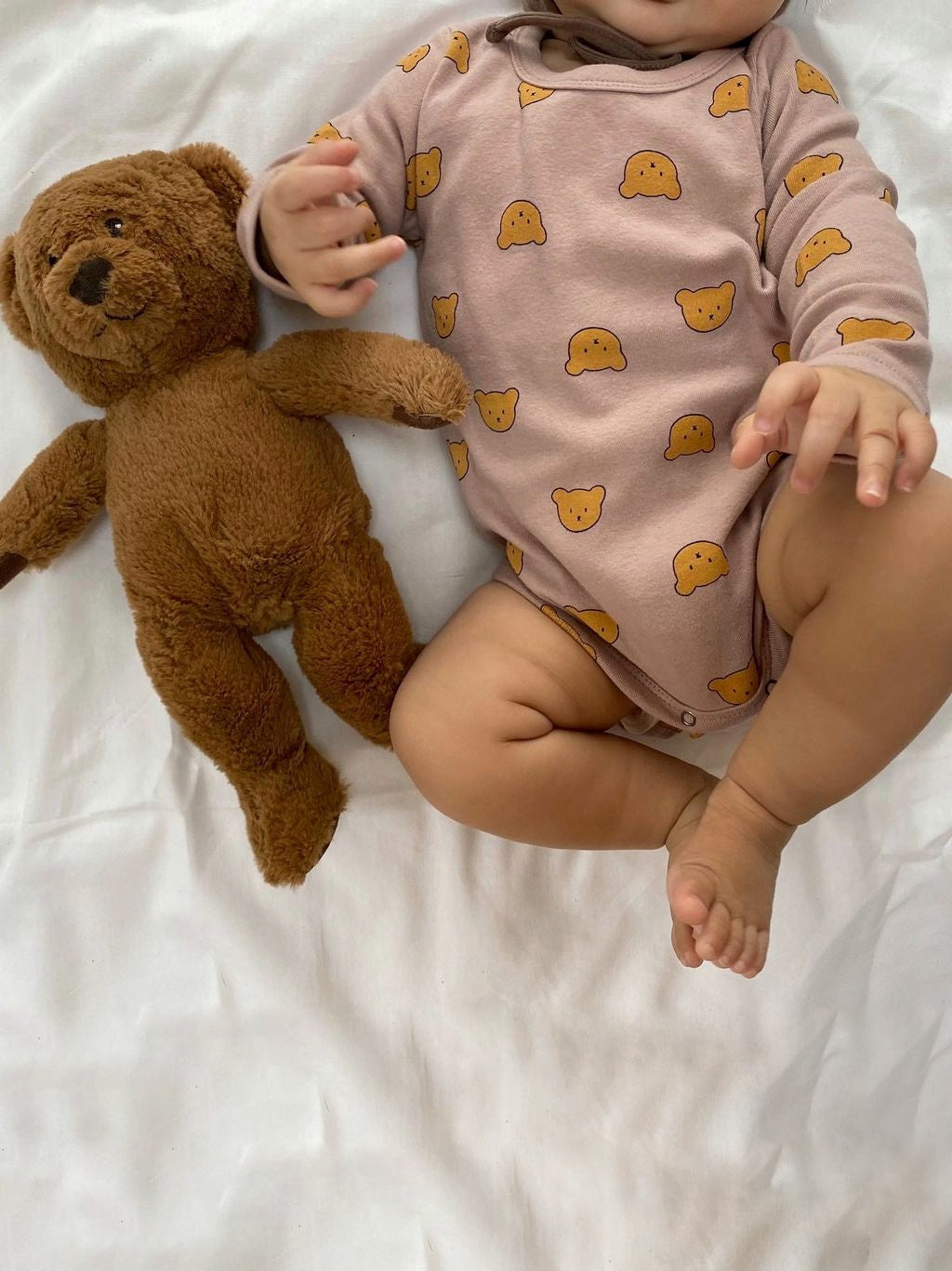 A baby wearing bear printed long sleeve bodysuit onesie