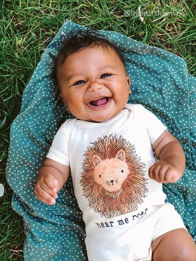 baby wearing mini + meep bear bodysuit with lion print
